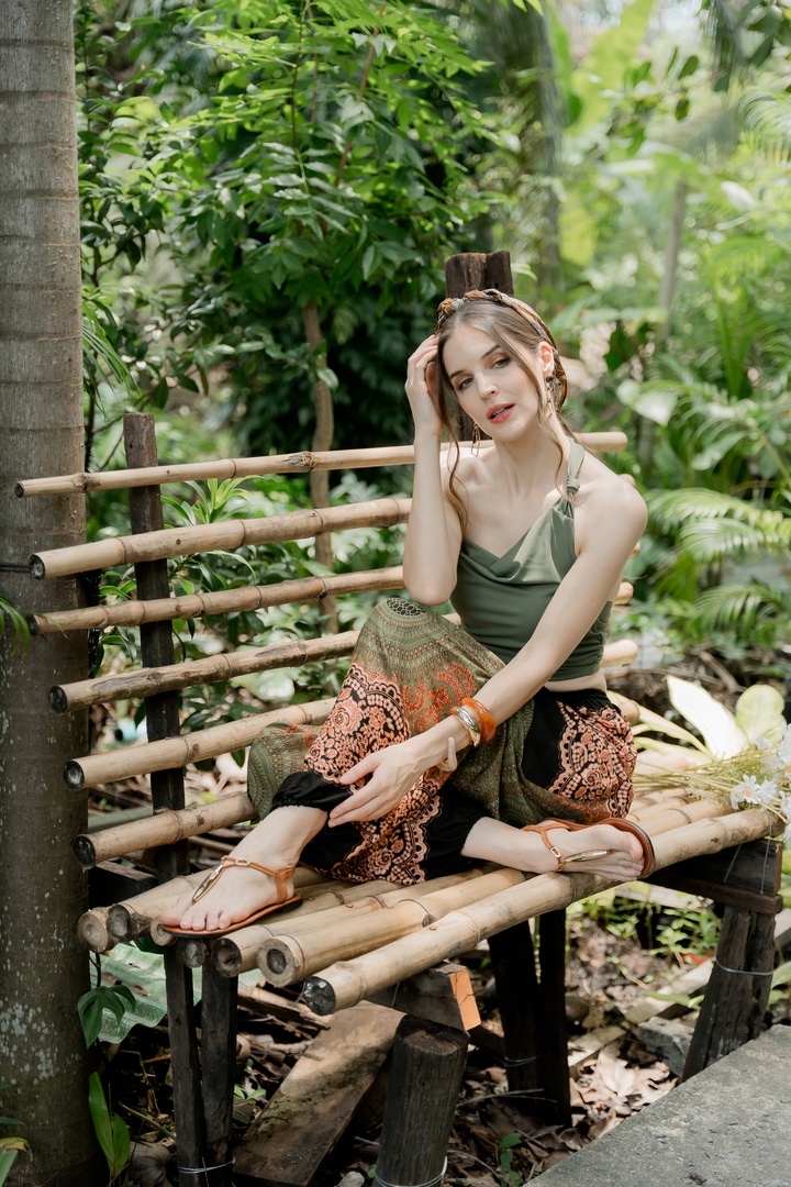 Creator relaxing in brown patterned pants on a bamboo bench