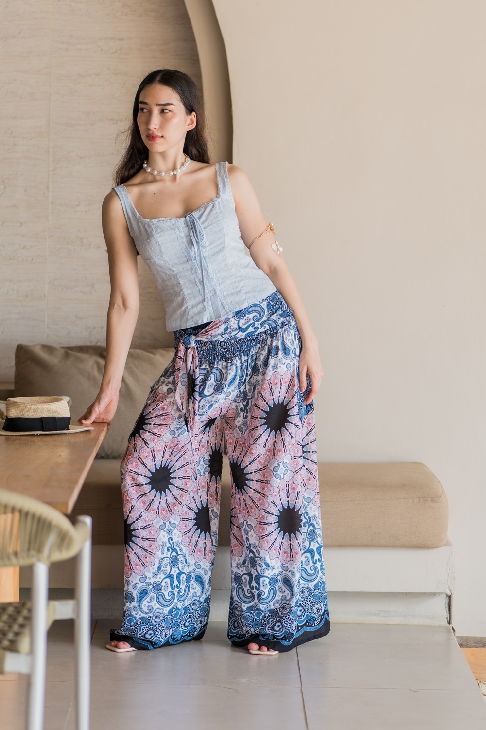 Patterned wide-leg pants styled in a warm neutral courtyard